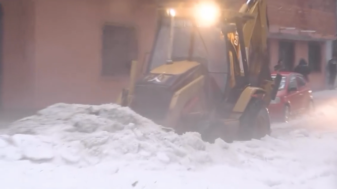 A backhoe scrapes hail from the ground in Tarija.